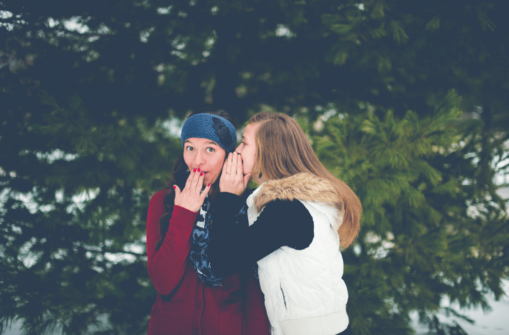 two girls whispering about their professor or teacher
