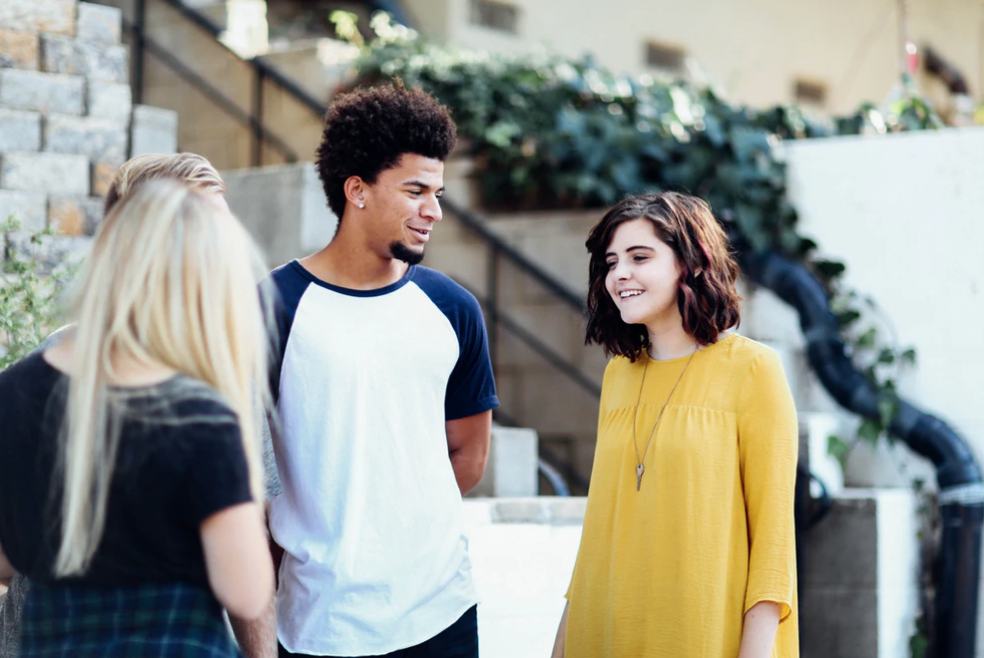 three students standing, talking