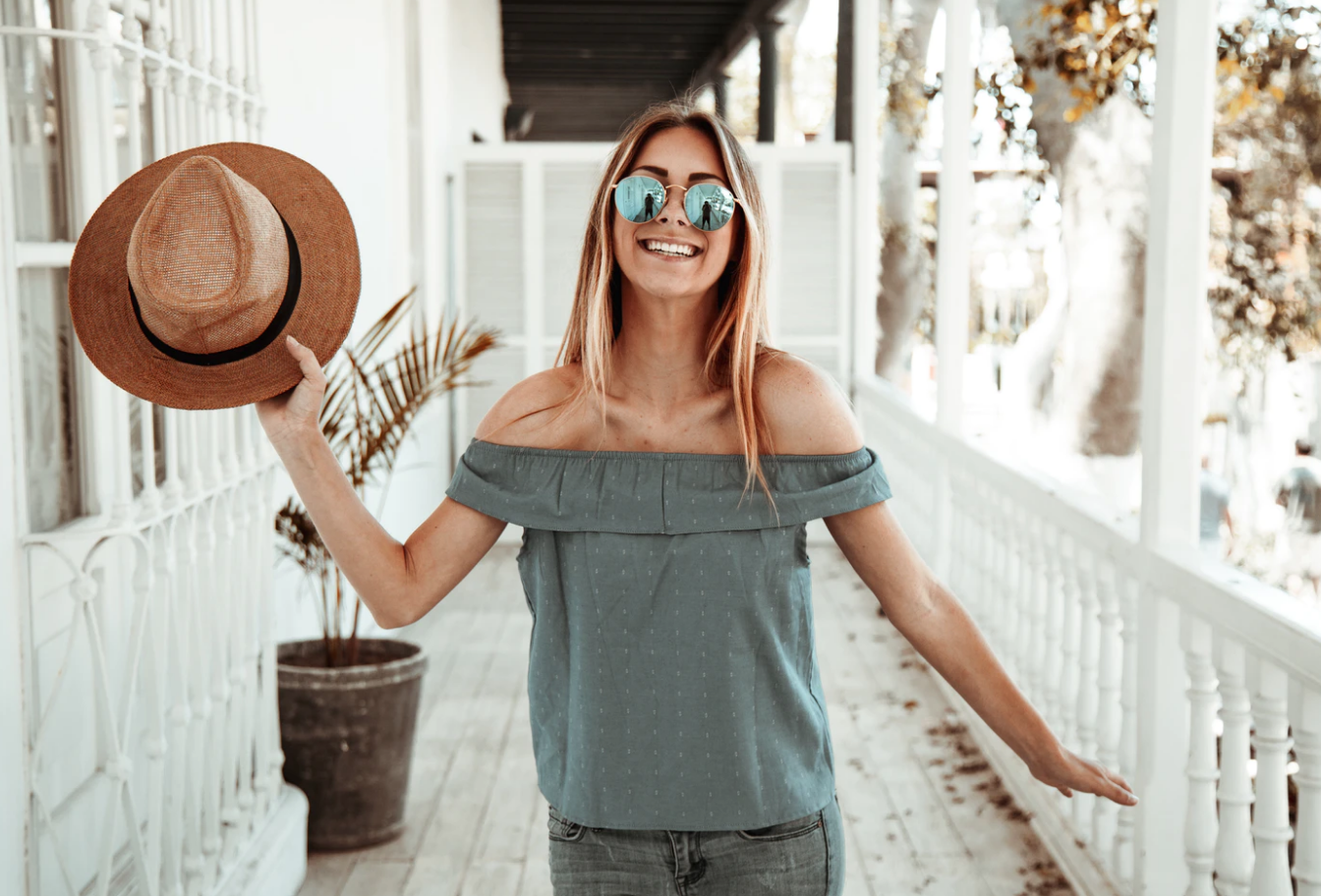 afford tuition costs, woman holding hat smiling