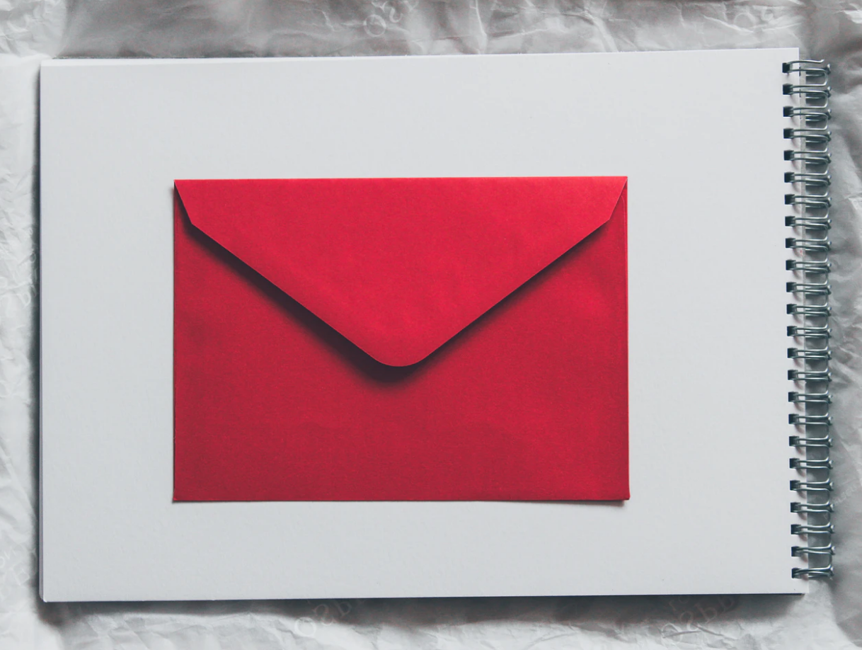 letter of recommendation red envelope lying flat on white sketchbook page